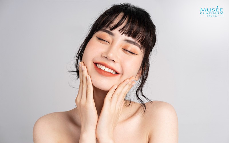 Young Woman Smiling While Touching Her Face
