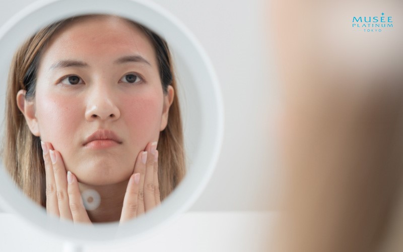 woman touching her face in front of mirror